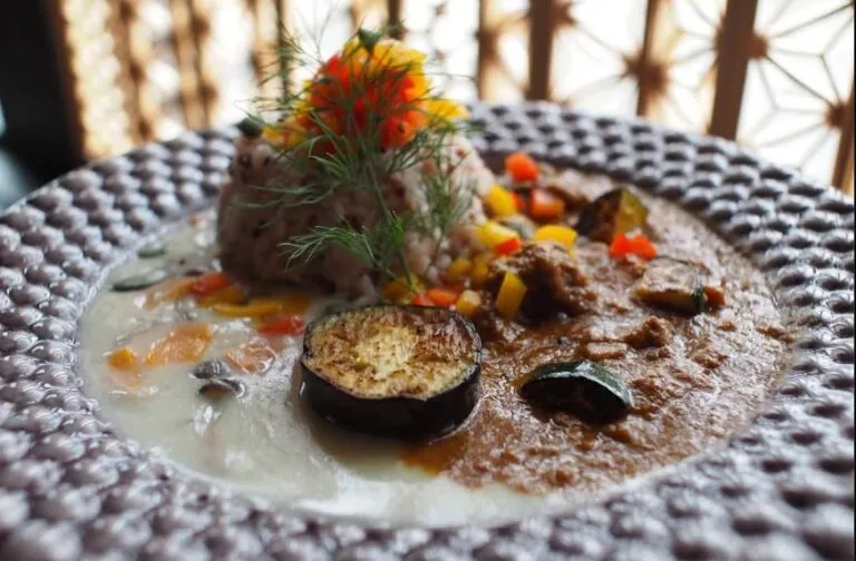 A beautifully plated gourmet vegan dish with vibrant vegetables and intricate presentation, served at a Kyoto fine dining restaurant