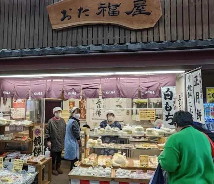 A vendor preparing fresh local dishes at a bustling Kyoto market, offering an authentic taste of the city