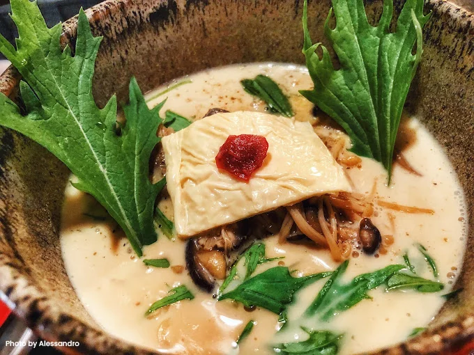 A warm bowl of Kyoto-style vegan udon topped with tofu and mushrooms, a comforting and delicious dish