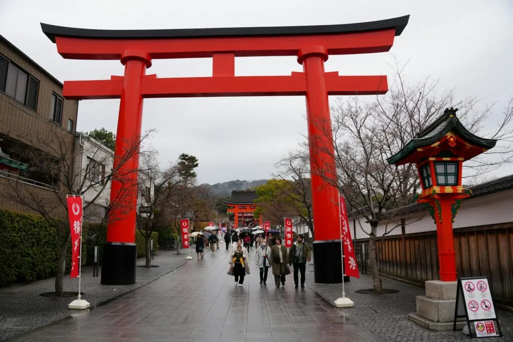 Visitors walking through the iconic torii gate path at Fushimi-Inari Shrine, a highlight of Kyoto free walking tours