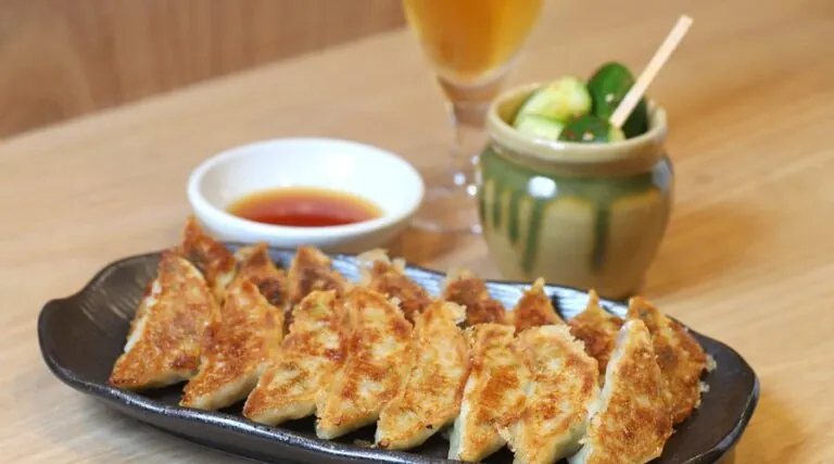 A platter of crispy vegan gyoza served with a savory dipping sauce, a must-try for plant-based food enthusiasts in Kyoto